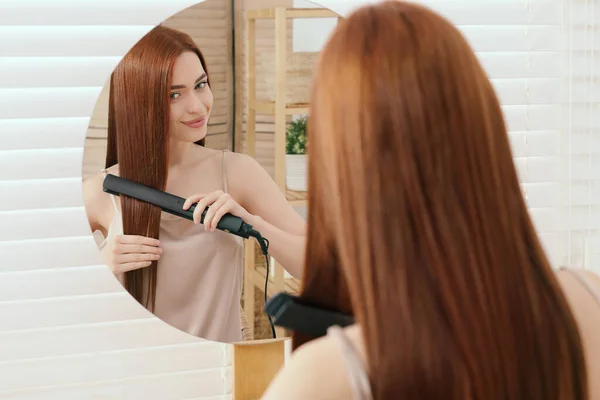 Krásná Žena Pomocí Vlasů Železa Blízkosti Zrcadla Pokoji — Stock fotografie