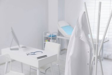 Klinikte askıda asılı duran beyaz doktor önlüğü. Metin için boşluk