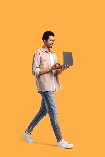 Homem Feliz Com Laptop Andando Sobre Fundo Laranja — Fotografia de Stock