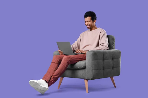 Hombre Feliz Con Portátil Sentado Sillón Sobre Fondo Púrpura — Foto de Stock