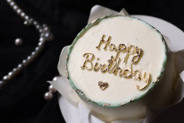 Siyah arkaplanda nefis dekore edilmiş doğum günü pastası, yakın plan.