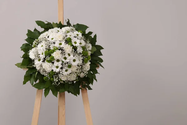 木立在灰色背景下的花的葬礼花环 案文的篇幅 — 图库照片