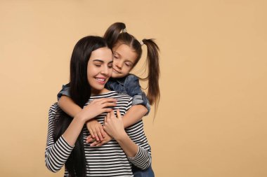 Bej arka planda kızı olan mutlu bir kadın. Mesaj için yer var. Anneler günü kutlaması.