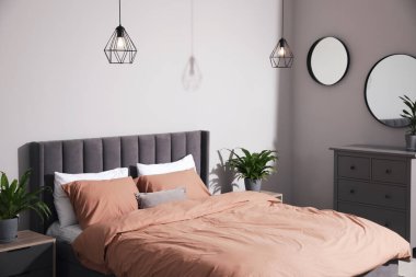 Şık bir yatak odası, rahat bir yatak odası ve yeşil bitkiler.