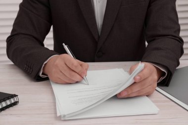 Ahşap masada belge imzalayan adam, yakın plan