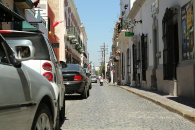 MONTERREY (NUEVO LEON), MEXICO - 29 Eylül 2022: Güneşli bir günde park halindeki arabalarla şehir caddesinin güzel manzarası