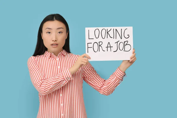 拿着标有 寻找浅蓝色背景工作 字样的失业亚洲妇女 — 图库照片