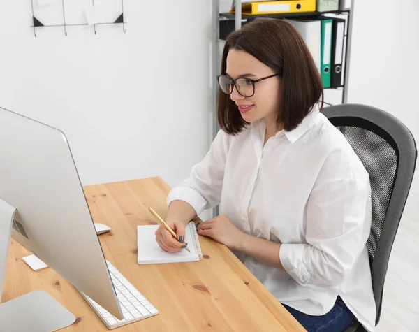 stock image Happy young intern working at table in modern office