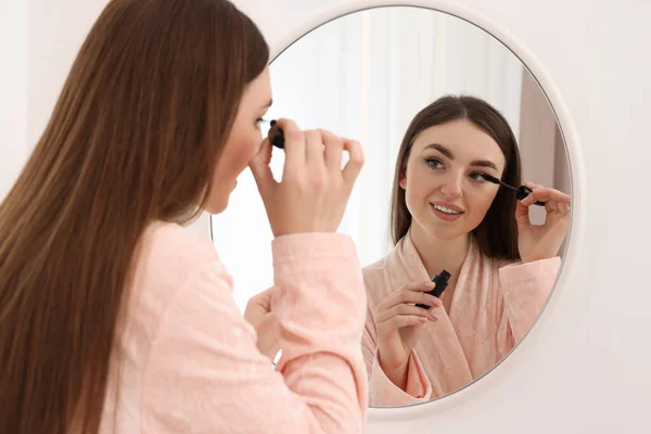Vacker Ung Kvinna Tillämpa Mascara Nära Spegel Inomhus — Stockfoto