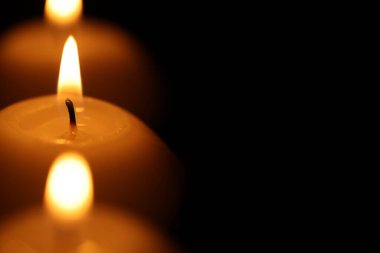 Siyah arka planda mum yakmak, yakın plan. Metin için boşluk