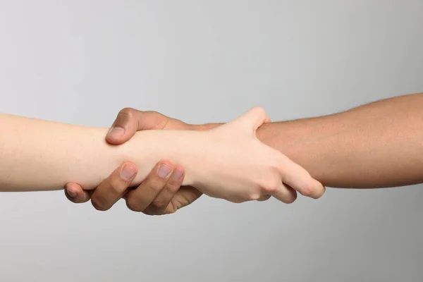 Διεθνείς Σχέσεις Άνθρωποι Κρατώντας Χέρια Ανοιχτό Γκρι Φόντο Closeup — Φωτογραφία Αρχείου