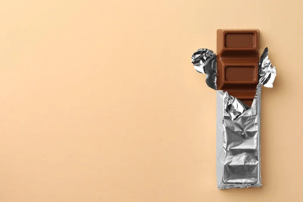 Deliciosa Barra Chocolate Envuelta Papel Aluminio Sobre Fondo Beige Vista — Foto de Stock