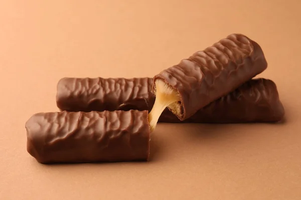 Doces Saborosas Barras Chocolate Com Caramelo Fundo Bege — Fotografia de Stock