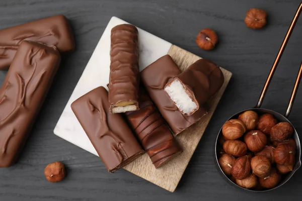 Bitar Olika Välsmakande Chokladkakor Och Hasselnötter Grått Träbord Platt Lägg — Stockfoto