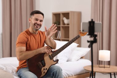 Evde online ders verirken öğrencilerle konuşan müzik öğretmeni. Hobi zamanı.