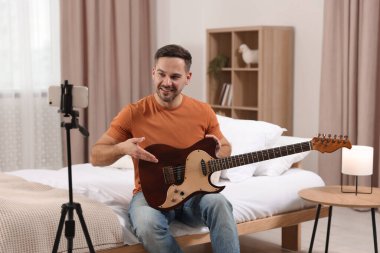 Evde online ders verirken gitarı gösteren müzik öğretmeni. Hobi zamanı.