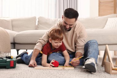 Baba ve oğul evde kalas ölçüyorlar. Onarım işi