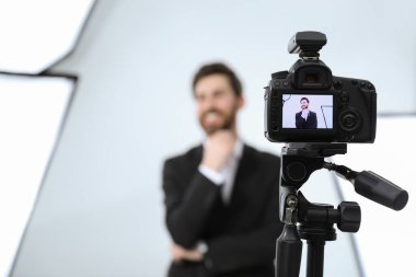 Modern stüdyoda kameraya poz veren yakışıklı mutlu model, seçici odaklanma. Profesyonel fotoğraf oturumu