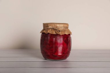 Beyaz ahşap masada pancar turşulu kavanoz.