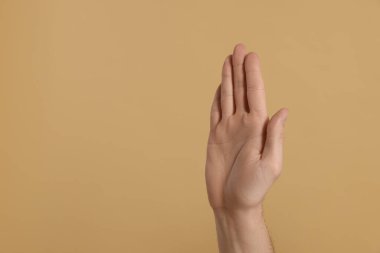 Adam bej arka planda beşlik çakıyor, eli yakın. Metin için boşluk