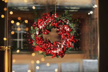 Beautiful Christmas wreath hanging on glass door