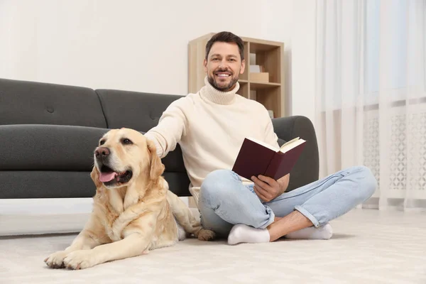 Άνθρωπος Διαβάζει Βιβλίο Στο Πάτωμα Κοντά Στο Χαριτωμένο Λαμπραντόρ Retriever — Φωτογραφία Αρχείου