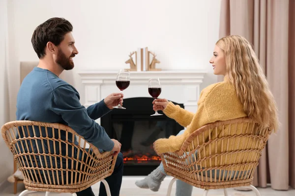 可爱的情侣们 带着酒杯在家里壁炉边共度时光 — 图库照片