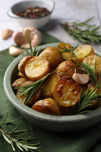 美味的烤土豆和香喷喷的迷迭香放在桌子上的碗里 — 图库照片