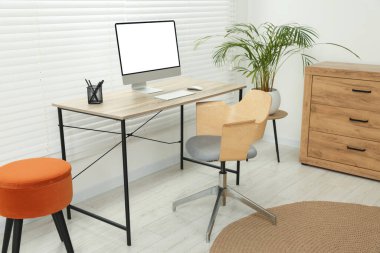 Rahat koltuğu, masası, bilgisayarı ve bitkisi olan şık bir ofis.