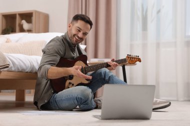 Evde online ders verirken öğrencilerle konuşan müzik öğretmeni. Hobi zamanı.