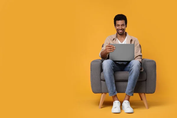 Homem Feliz Com Laptop Sentado Poltrona Fundo Laranja Espaço Para — Fotografia de Stock