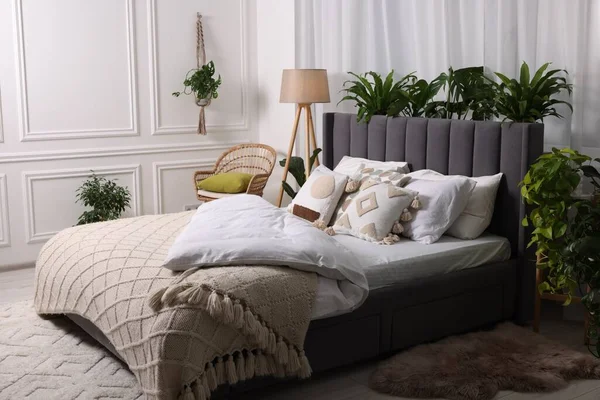ベッドルームで大きな快適なベッド ランプ 美しい観葉植物 インテリアデザイン — ストック写真