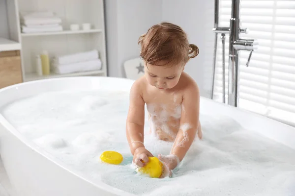 可爱的小女孩带着橡胶鸭在家里泡泡浴 — 图库照片