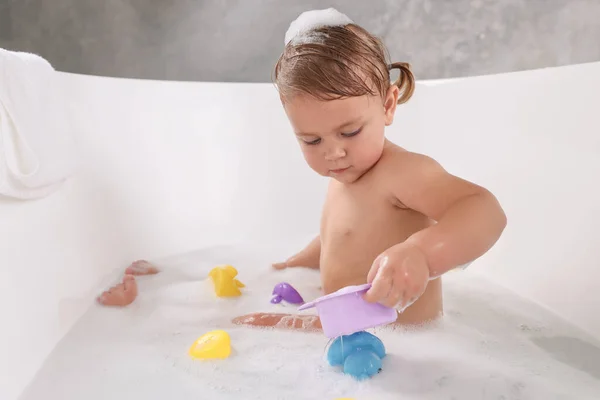 Cute Little Girl Biorąc Kąpiel Bańce Zabawkami Wewnątrz — Zdjęcie stockowe
