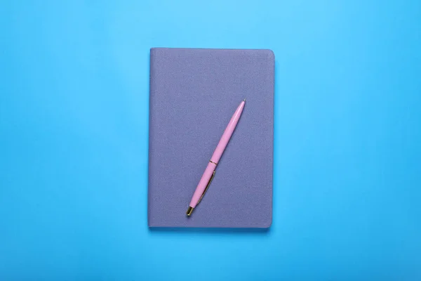 Uzavřený Notebook Pero Světle Modrém Pozadí Horní Pohled — Stock fotografie