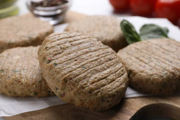 stock image Raw vegan cutlets on wooden board, closeup