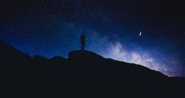 Güzel yıldızlı gökyüzünün altındaki dağlarda insan silueti Hilal ay ve gece pankart tasarımı