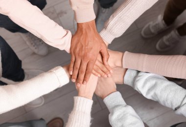 İçerde el ele tutuşan çok ırklı insanlardan oluşan bir grup.