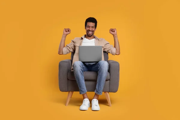 Homem Emocional Com Laptop Sentado Poltrona Fundo Laranja — Fotografia de Stock