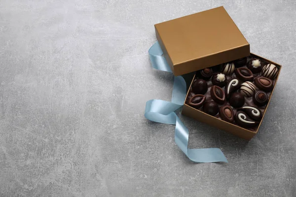 Otevřená Krabice Lahodných Čokoládových Bonbónů Barevná Stuha Světle Šedém Stole — Stock fotografie