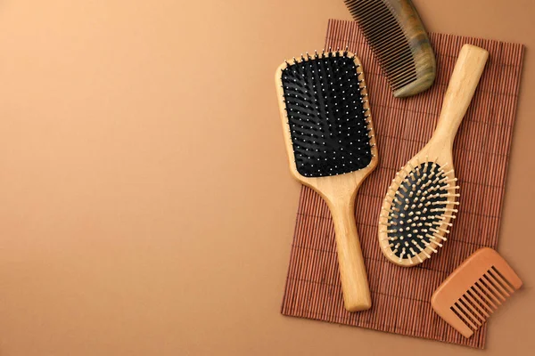 stock image Wooden hairbrushes and combs on light brown background, flat lay. Space for text