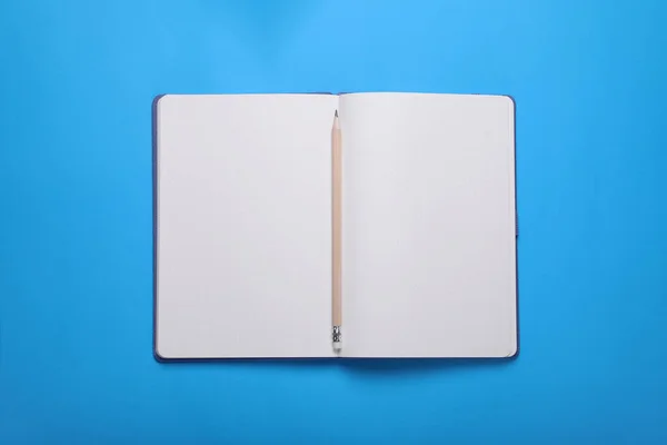 Otevřít Zápisník Tužku Světle Modrém Pozadí Horní Pohled — Stock fotografie