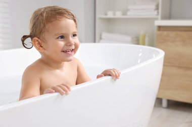 Tatlı küçük kız evde banyo yapıyor.