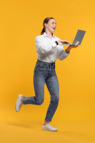 Щаслива Жінка Ноутбуком Працює Помаранчевому Фоні — стокове фото