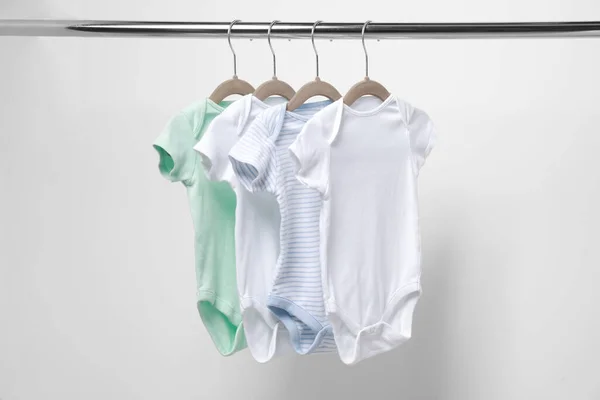 Baby Bodysuits Opknoping Rek Buurt Van Witte Muur Close — Stockfoto