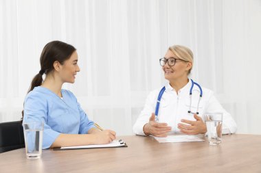 Tıp konferansı. Doktorlar ofisteki ahşap masada tartışıyorlar.