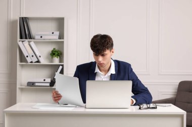 Ofisteki beyaz masada çalışan genç adam. Son teslim tarihi kavramı