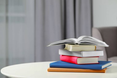 Beyaz masa içerisindeki ciltli kitaplar yığını, metin için boşluk