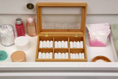 Tampon deposu ve beyaz çekmecede farklı hijyen ürünleri.