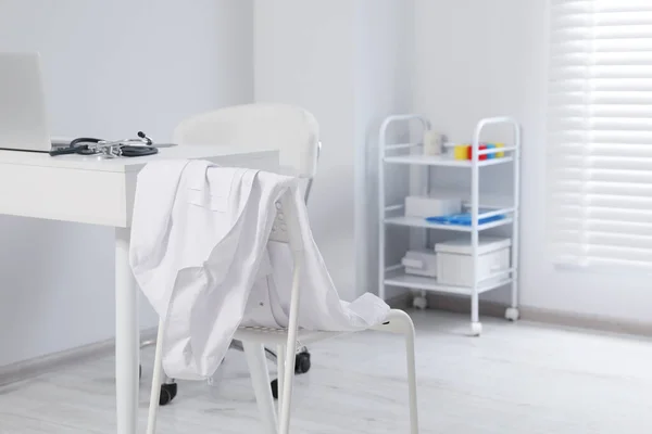 Λευκό Φόρεμα Γιατρού Κρέμεται Καρέκλα Στην Κλινική — Φωτογραφία Αρχείου